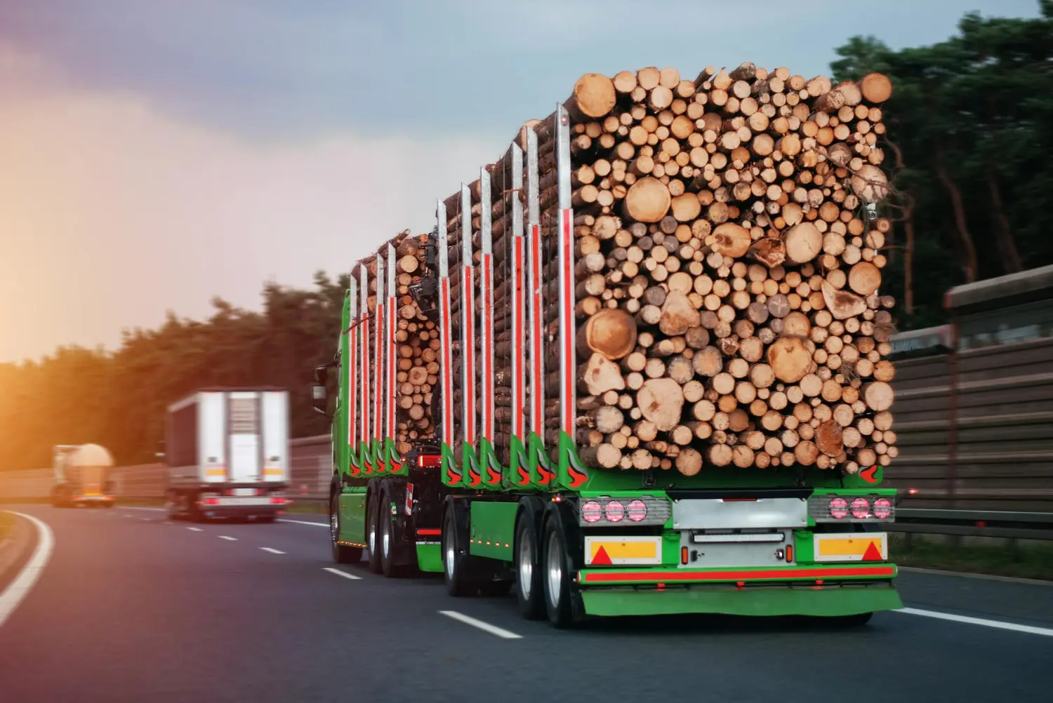 Imagem de caminhão carregado com toras de madeira, reforçando a importância dos equipamentos certos para transporte florestal.